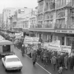 In Wellington workers stop work and march to the Employers Federation office protesting about the use of injunctions preventing workers withdrawing there labour. The march was also in solidarity with Bill Andersen imprisoned for defying a Supreme Court injunction.