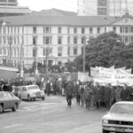 In Wellington workers stop work and march to the Employers Federation office protesting about the use of injunctions preventing workers withdrawing there labour. The march was also in solidarity with Bill Andersen imprisoned for defying a Supreme Court injunction.