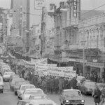 In Wellington workers stop work and march to the Employers Federation office protesting about the use of injunctions preventing workers withdrawing there labour. The march was also in solidarity with Bill Andersen imprisoned for defying a Supreme Court injunction.